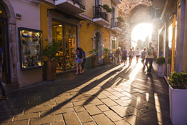 Tourists entering Corso Umberto, the main street in Taormina at sunset, Sicily, Italy, Europe 