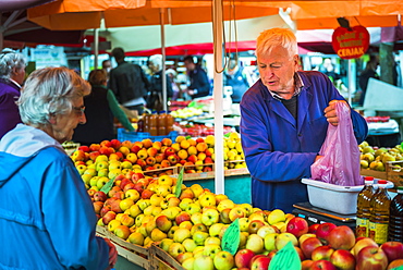 Market stall owner in Ljubljana Central Market on a Saturday in Vodnikov Trg, Ljubljana, Slovenia, Europe