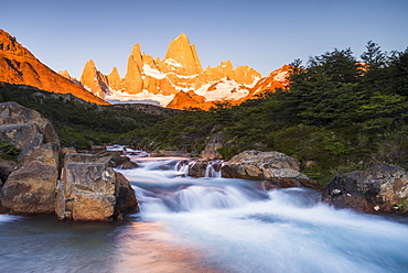 Sunrise Mount Fitz Roy (Cerro Chalten) and waterfall seen on Lago de los Tres hike, UNESCO World Heritage Site, El Chalten, Patagonia, Argentina, South America