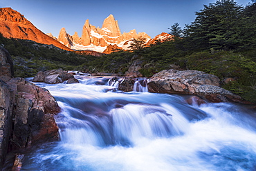 Sunrise Mount Fitz Roy (Cerro Chalten) and waterfall seen on Lago de los Tres hike, UNESCO World Heritage Site, El Chalten, Patagonia, Argentina, South America