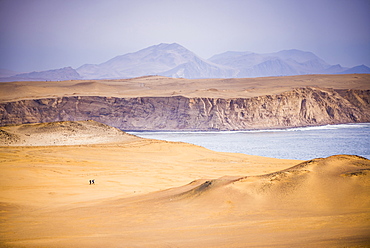 Hikers hiking in desert and sand dunes, Paracas National Reserve (Reserva Nacional de Paracas), Ica, Peru, South America