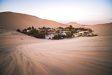 Huacachina and sand dunes at sunset in the desert in the Ica Region, Peru, South America