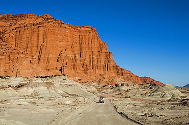 Driving past red Los Coloradas Cliff, Valley of the Moon (Valle de la Luna), Ischigualasto Provincial Park, San Juan Province, Argentina, South America