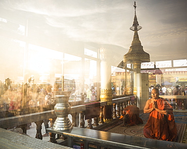 Buddhist Monks praying at Golden Rock Temple (Kyaiktiyo Pagoda) at sunset, Mon State, Myanmar (Burma), Asia