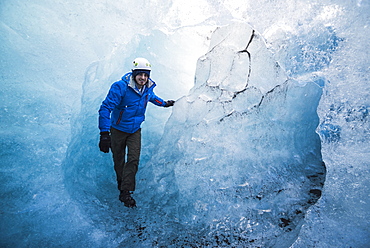 Tourist exploring an ice cave on Breidamerkurjokull Glacier, Vatnajokull Ice Cap, Iceland, Polar Regions