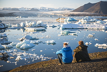 Father and son on holiday at Jokulsarlon Glacier Lagoon at sunset, South East Iceland, Iceland, Polar Regions