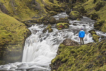 Tourist at a waterfall on the hiking trail above Skogafoss Waterfall, Skogar, South Region (Sudurland), Iceland, Polar Regions