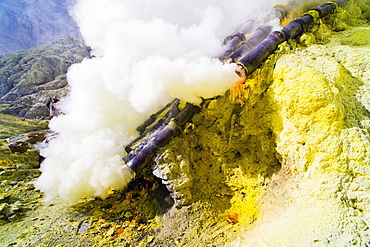 Toxic sulphur fumes escaping from the ceramic pipes at Kawah Ijen, Java, Indonesia, Southeast Asia, Asia