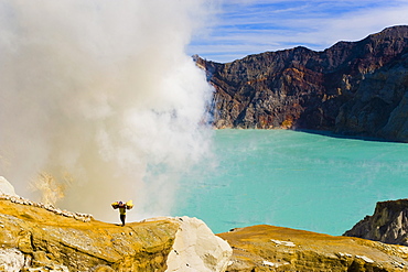 Sulphur worker appearing out of toxic fumes at Kawah Ijen, East Java, Indonesia, Southeast Asia, Asia