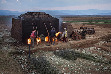 Brick workers firing a kiln near Antsirabe, Vakinankaratra Region, Madagascar, Africa