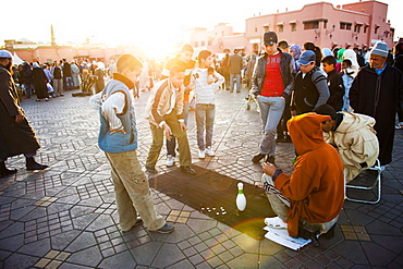 Moroccan people playing street games in Place Djemaa El Fna, the famous square in Marrakech, Morocco, North Africa, Africa 