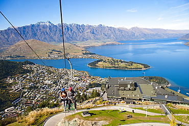 Two tourists on the gondola to the luge track above Queenstown, Otago, South Island, New Zealand, Pacific