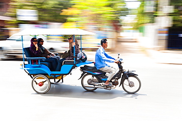 Motion blurred tourists in a tuk tuk speeding along the streets of Siem Reap, Cambodia, Indochina, Southeast Asia, Asia