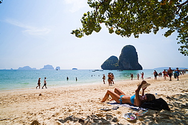 Tourist sunbathing and reading on Ao Phra Nang Beach, Railay (Rai Leh), South Thailand, Southeast Asia, Asia