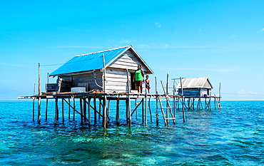 Women and young boy in hut built over the water by Bajau fishermen, who live there for three months, Togian Islands, Indonesia, Southeast Asia, Asia