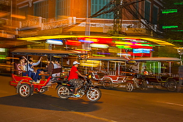 Motion blur image of a tuk-tuk at night in the capital city of Phnom Penh, Cambodia, Indochina, Southeast Asia, Asia