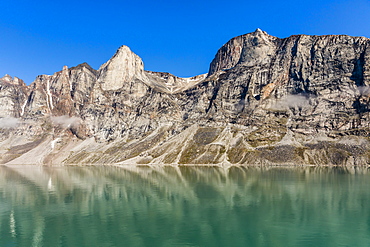 Reflections on a calm sea of the steep cliffs of Icy Arm, Baffin Island, Nunavut, Canada, North America