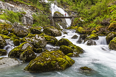 Slow shutter speed silky water of the Olden River and bridge as it flows along Briksdalen, Olden, Nordfjord, Norway, Scandinavia, Europe