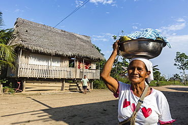 Woman carrying food in bowl, San Miguel Caño, Upper Amazon River Basin, Loreto, Peru, South America