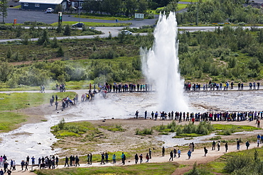 Tourists watch the eruption of the Strokkur geyser, Haukadalur valley, Hvita River, Iceland, Polar Regions