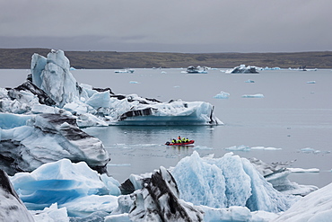 Boat amongst calved ice from the Breidamerkurjokull glacier in Jokulsarlon glacial lagoon, Iceland, Polar Regions