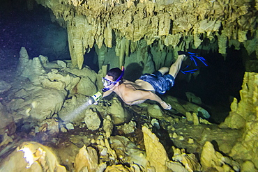 A snorkeler explores the fresh water grotto formations at Makatea, Tuamotus, French Polynesia, South Pacific, Pacific