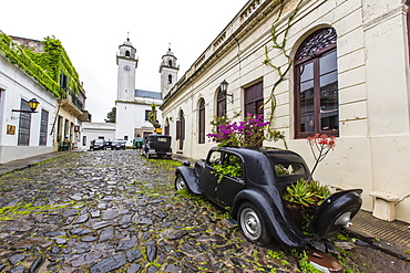 Old car turned into planter on cobblestone street in Colonia del Sacramento, Uruguay, South America