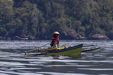 Fisherman in an outrigger canoe, Bangka Island, off the northeastern tip of Sulawesi, Indonesia, Southeast Asia, Asia