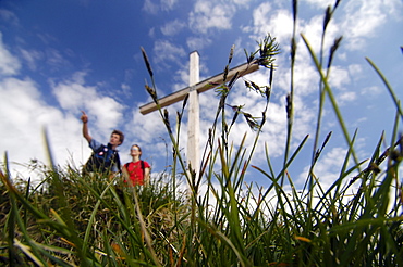 Hikers at a summit cross at the Allgaeu Alps, Bavaria, Germany, Europe