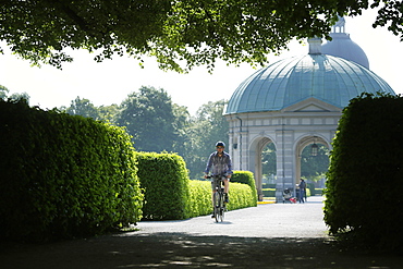 Man riding an e-bike through Hofgarten, Munich, Upper Bavaria, Germany