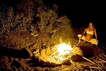 Pregnant woman standing near a campfire, Conejo, Baja California Sur, Mexico