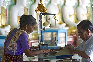 Gold leaf salesperson in Oohmin Thonze pagoda, Sagaing Hill on the banks of Irrawaddy river, 20km from Mandalay, Myanmar, Burma