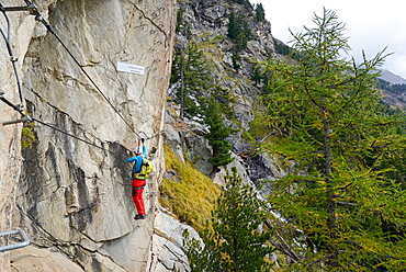 Woman climbing the via ferrata La Resgia, Engadin, Grisons, Switzerland