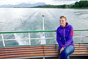 Woman sitting on a ferry bank, lake Chiemsee, Chiemgau, Bavaria, Germany