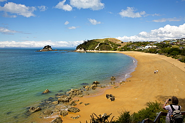 View of the sandy beach of Tasman Bay and Torlesse Rock on a sunny day at Abel Tasman National Park, near Kaiteriteri, Tasman Re