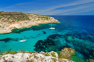 A sailing yacht and a fishing boat anchored in a lonely bay with clear blue water, Mallorca, Balearic Islands, Spain, Europe