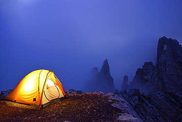 Illuminated tent standing in front of Torre di Pisa, Torre di Pisa, Latemar range, Dolomites, UNESCO world heritage Dolomites, Trentino, Italy