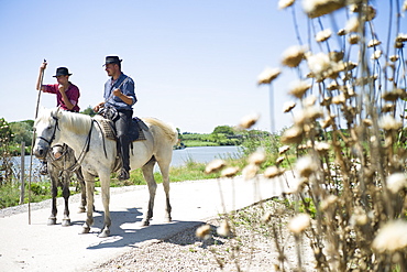 Gardians and their Camargue horse in front of their Manade, near Aigues-Mortes, Camargue, Gard, Languedoc-Roussillon, France