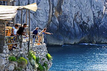 People fishing at the rocky coast in the sunlight, Capri, Italy, Europe