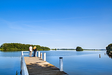 Couple on a pier at lake Ploen, Bosau, Holstein Switzerland, Ostholstein, Schleswig-Holstein, Germany