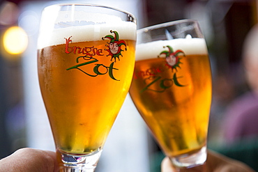 Toasting with two glasses of Brugse Zot beer in a restaurant in the Old Town, Bruges Brugge, Flemish Region, Belgium