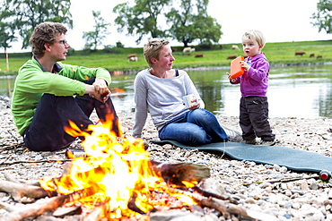 Family sitting around the campfire, Camping along the river Elbe, Family bicycle tour along the river Elbe, adventure, from Torgau to Riesa, Saxony, Germany, Europe