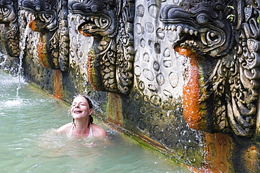 Female tourist bathing in hot spring air panas, Banjar Tegeha, Buleleng, Bali, Indonesia