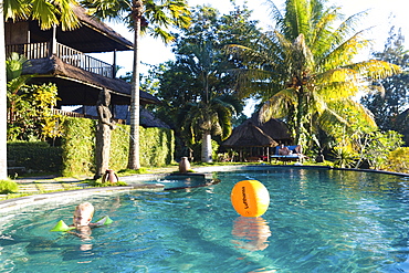 Boy bathing in a hotel swimming pool, Sidemen, Bali, Indonesia