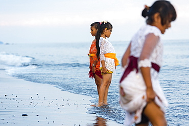 Girls standing in shallow water, Odalan, Pura Goa Lawah, Padangbai, Bali, Indonesia