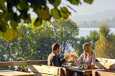 Young couple at a beer garden in the sunlight, lake Tegernsee, Bavaria, Germany, Europe