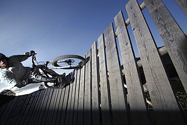 Mountain biker passing wallride, Oberammergau, Bavaria, Germany