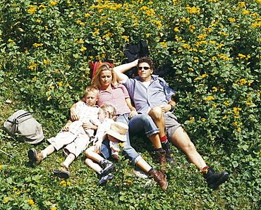 Family lying on grass, Eng, Kleiner Ahornboden, Tyrol, Austria