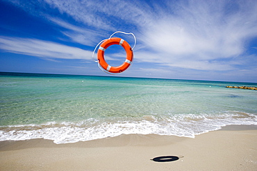 Lifebelt flying over sandy beach, Apulia, Italy