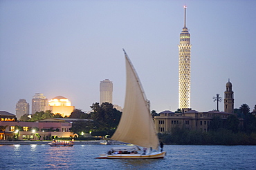 Feluka on the river Nile at dusk, Cairo Tower and opera house in the background, Cairo, Egypt, Africa